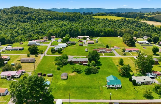 Aerial photo, land, 0.331+/- acres, neighboring homes, road, trees, mountains