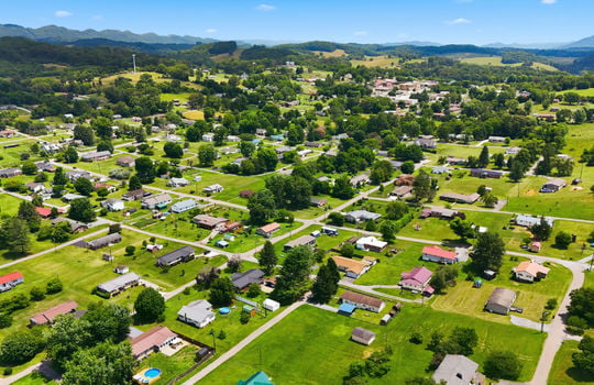 Aerial photo, land, 0.331+/- acres, neighboring homes, road, trees, mountains