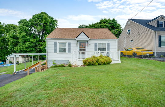 One Level Cottage, front yard, landscaping, front porch, stairs, carport, shingle roof, vinyl siding, driveway, neighboring homes, fencing, trees