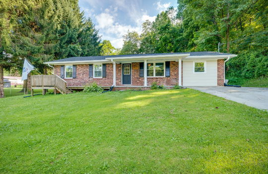 brick, ranch, concrete driveway, covered front porch, steps, front yard, front door, trees