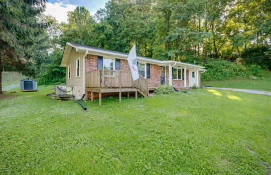Left side view of home, brick, ranch, porch, covered front porch, porch steps, front yard, driveway, side yard, trees