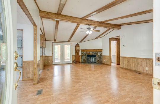 living room, laminate flooring, ceiling fan, double doors, fireplace