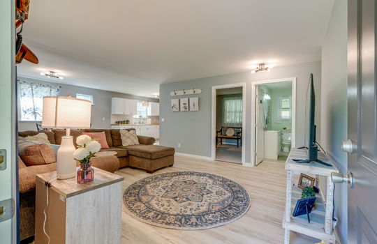 living room, luxury vinyl flooring, doorway to bathroom, open concept to kitchen and dining area, luxury vinyl flooring