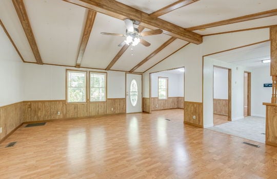 living room, laminate flooring, ceiling fan, front door, windows