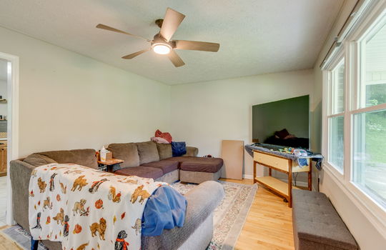 living room, windows, ceiling fan, hardwood flooring, doorway to kitchen