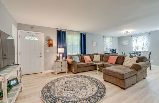 living room, front door, luxury vinyl flooring, windows