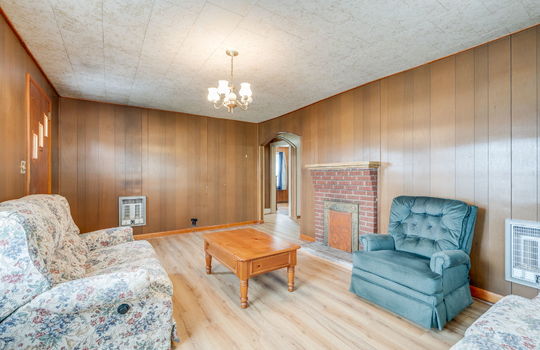 living room, paneling walls, fireplace, front door, arched doorway