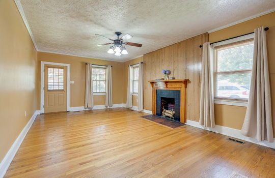 living room, exterior door, hardwood flooring, windows, fireplace, ceiling fan