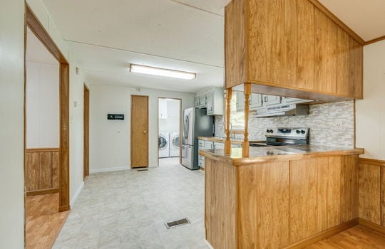 kitchen, vinyl flooring, stainless appliances, sink, tile backsplash, cabinets, countertops, fluorescent lighting