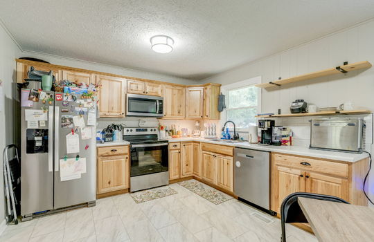kitchen, cabinets, countertops, stainless steel appliances, dishwasher, electric range, built-in microwave, refrigerator, sink, window above sink, shelving