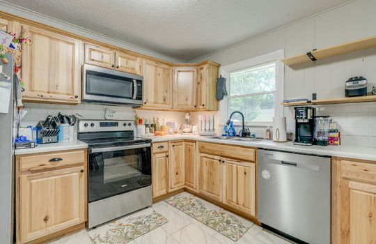 kitchen, cabinets, countertops, stainless steel appliances, dishwasher, electric range, built-in microwave, refrigerator, sink, window above sink, shelving