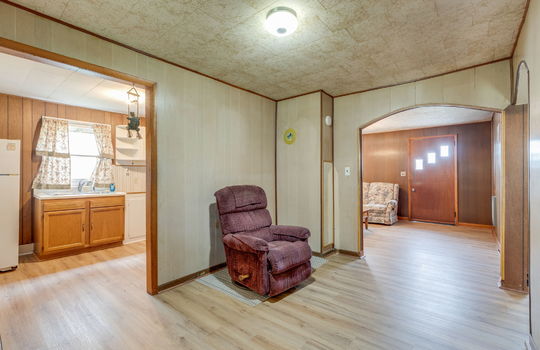dining room, laminate flooring, paneling walls, doorway to living room, doorway to kitchen