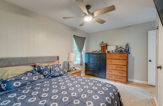 bedroom, painted paneling walls, hardwood flooring, ceiling fan, closet, window