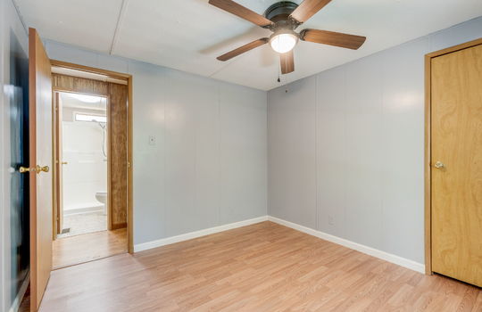 second bedroom, door to hallway, laminate flooring, ceiling fan, closet