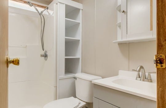second bathroom, toilet, shower, sink, vinyl flooring