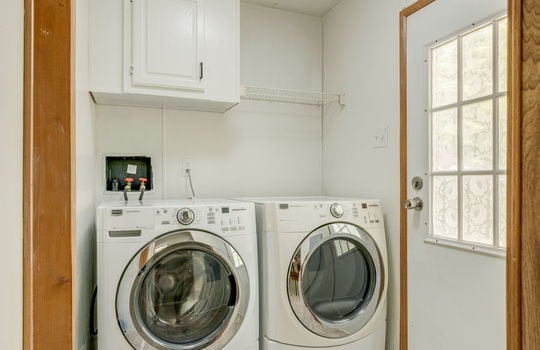 laundry room, washer/dryer hookups, exterior door, wire shelving, cabinet door, vinyl flooring