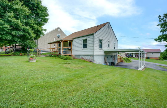 back yard, back view of home, carport, back porch, covered back porch, cottage, vinyl siding, driveway