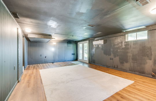 finished basement, exterior walk-out doors, luxury vinyl flooring, windows, painted paneling