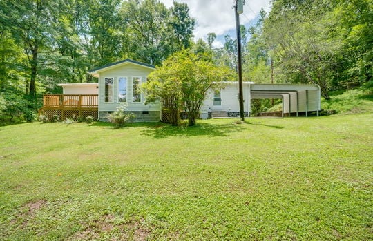 back of home, sunroom, back deck, back entry door, carport, back yard, trees, landscaping