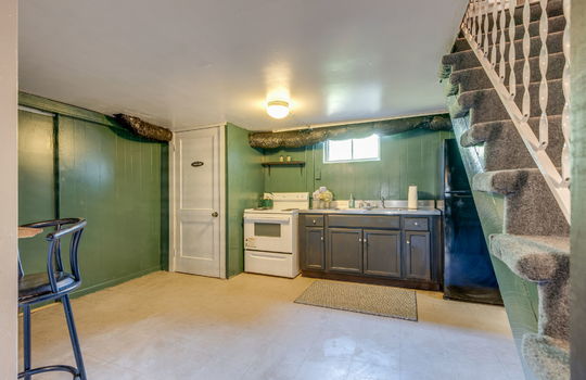 secondary kitchen, vinyl flooring, oven/range, refrigerator, sink, cabinets, countertop, stairs to main level, window