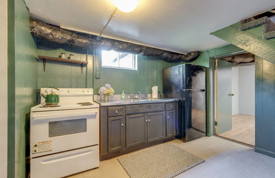 secondary kitchen, vinyl flooring, oven/range, refrigerator, sink, cabinets, countertop, stairs to main level, window, doorway