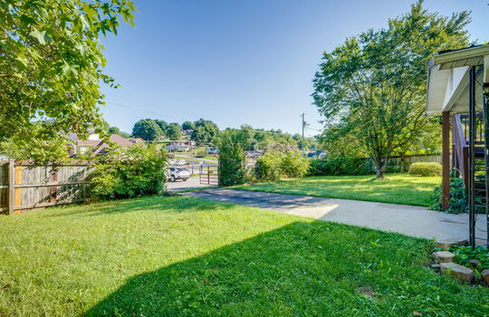 back yard, driveway, carport, trees, fencing, landscaping