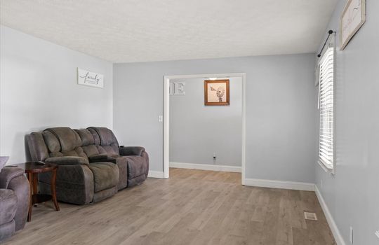living room, luxury vinyl flooring, window, doorway to foyer/entryway