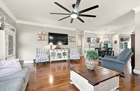 living room, open floor plan to diing space and kitchen, hardwood flooring, oversized ceiling fan