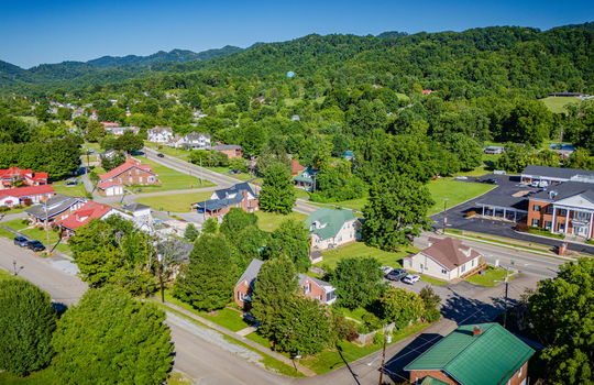 Aerial view of home, surrounding homes, neighborhood, sidewalk, mountains