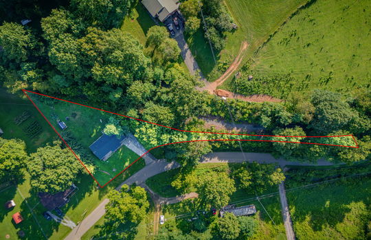aerial view of home, road, concrete driveway, roof, front yard, back yard, storage shed, trees, neighboring homes, property outline