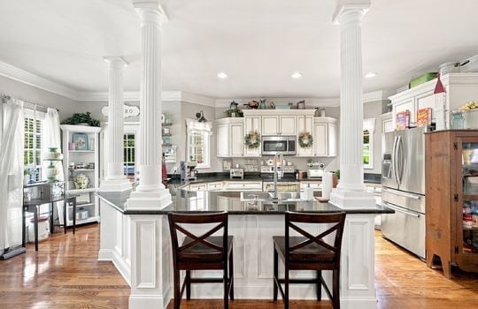 kitchen, island, sink in island, granite countertops, cabinets, stainless steel appliances, refrigerator, microwave, oven/range, recessed lighting, hardwood flooring, exterior door