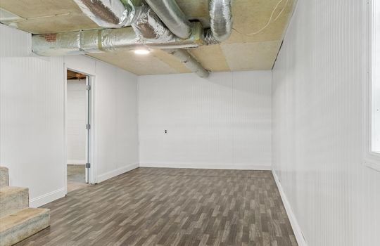 bonus room, beadboard walls, luxury vinyl flooring, door to garage