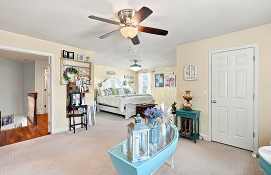 bedroom,carpet, door to ensuite bath, windows, ceiling fan