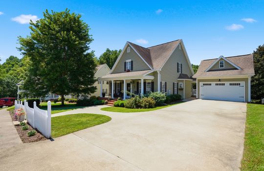 driveway view of home, traditional home, vinyl siding, two car garage, shingle roof, covered front porch, sidewalk, front door, landscaping