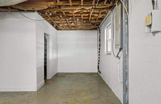 garage space, concrete flooring, electrical panel, window, doorway