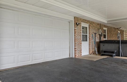 exterior view toward garage door, garage door, entryway, windows, brick exterior, driveway