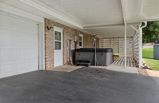 lower level patio space, covered garage entry, garage door, entryway door, windows