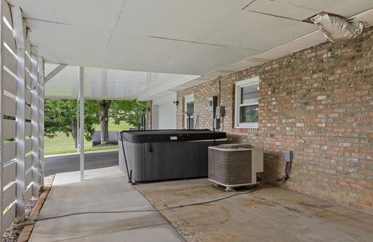 lower level patio space, concrete, garage door, entryway door, windows, brick exterior