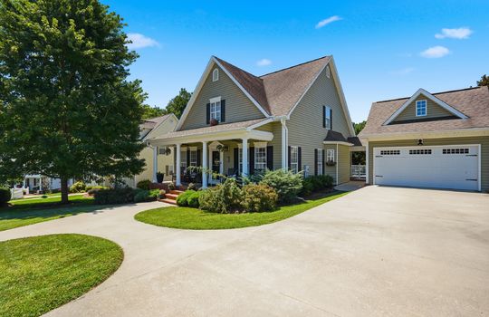 driveway view of home, traditional home, vinyl siding, two car garage, shingle roof, covered front porch, sidewalk, front door, landscaping