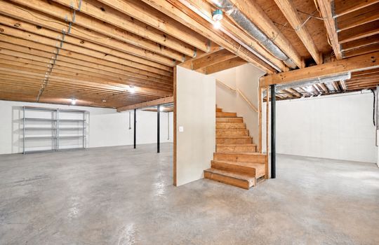 Unfinished basement, stairs to main level, concrete flooring