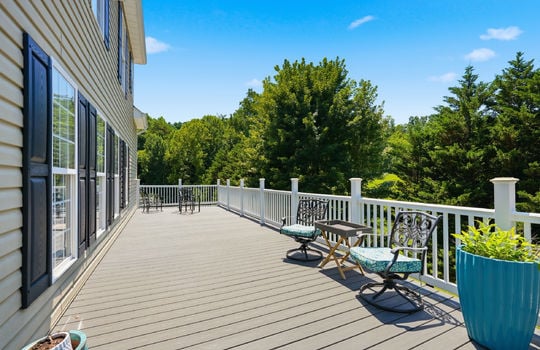 back deck, railings, view of trees in back yard, vinyl siding