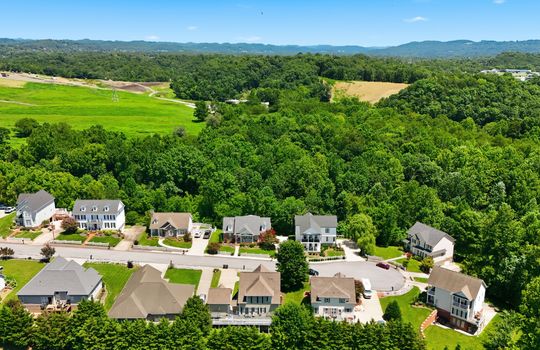 aerial view of home, front of home, sidewalk, driveway, concrete driveway, garage, 2 car garage, shingle roof, neighboring homes, mountains, cul-de-sac