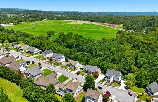 aerial view of home, front of home, sidewalk, driveway, concrete driveway, garage, 2 car garage, shingle roof, neighboring homes, mountains, cul-de-sac
