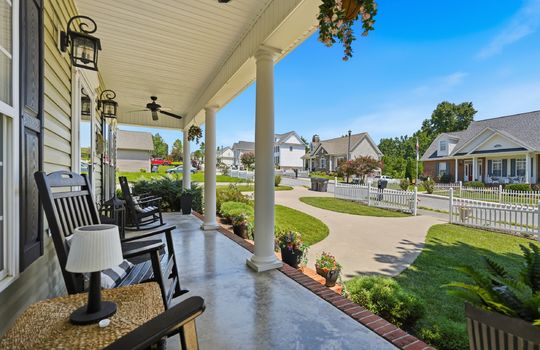 covered front porch, front yard view, sidewalk, landscaping, fence, front door, outdoor ceiling fans, concrete porch