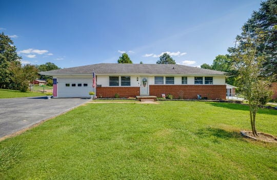 Ranch style home, brick, vinyl siding, garage, asphalt driveway, front stoop, landscaping, front door, front yard