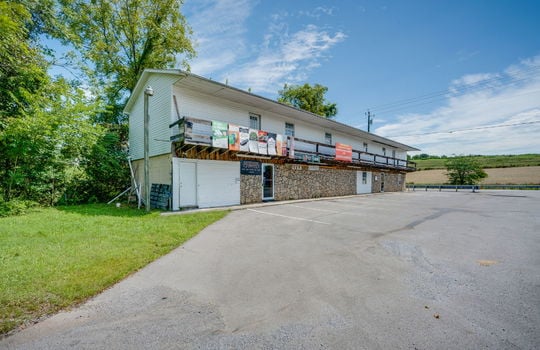 commercial space for lease, glass door, stone & vinyl siding exterior, parking lot, parking spaces, road