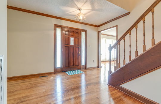 foyer, front door, hardwood flooring, wood stairs