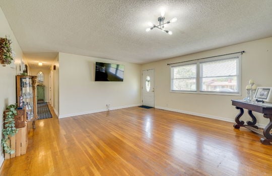 living room, hardwood flooring, window, front door, hallway