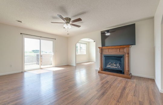 living room, luxury vinyl flooring, arched doorway, ceiling fan, sliding glass door