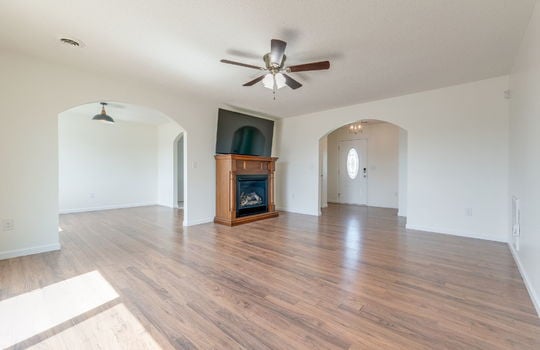 living room, arched door to front door, arched door to dining area, luxury vinyl flooring, ceiling fan